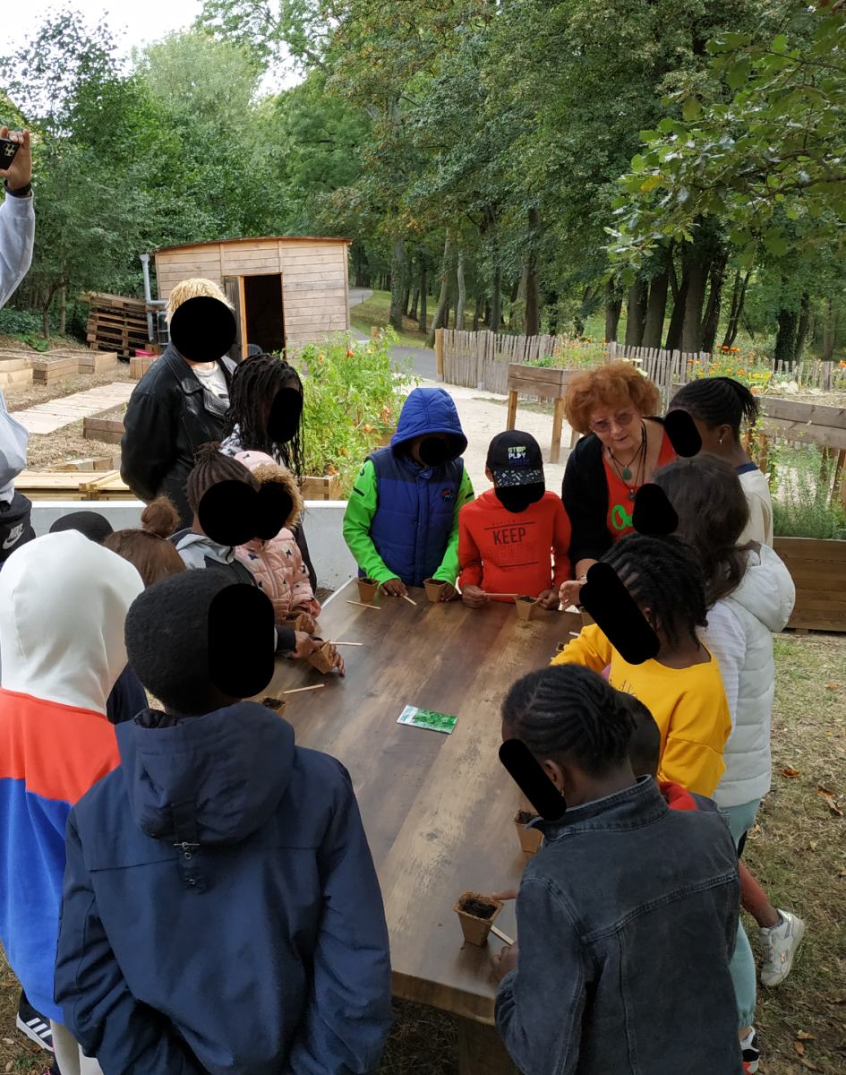 Les enfants écoutant les explications de notre responsable Jardin sur la plantation du persil